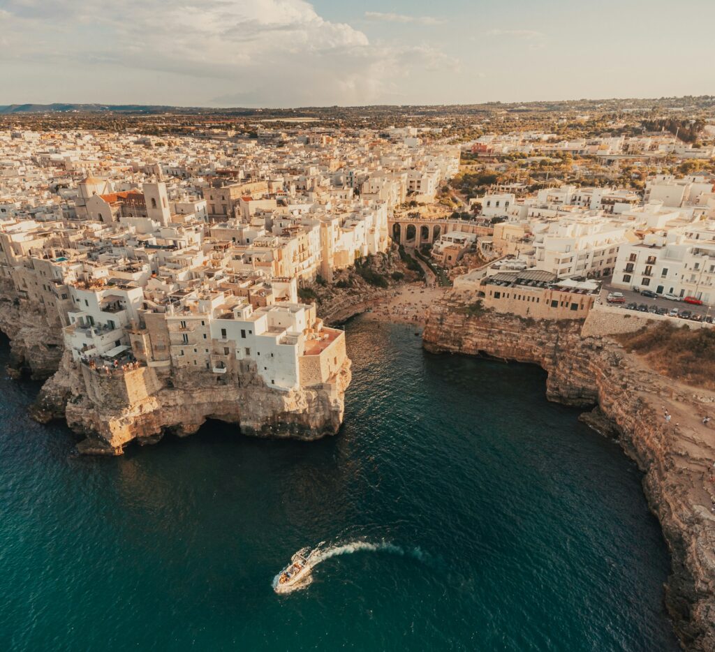 Una barca galleggia sull'acqua vicino alla costa di Polignano a Mare, in Puglia.