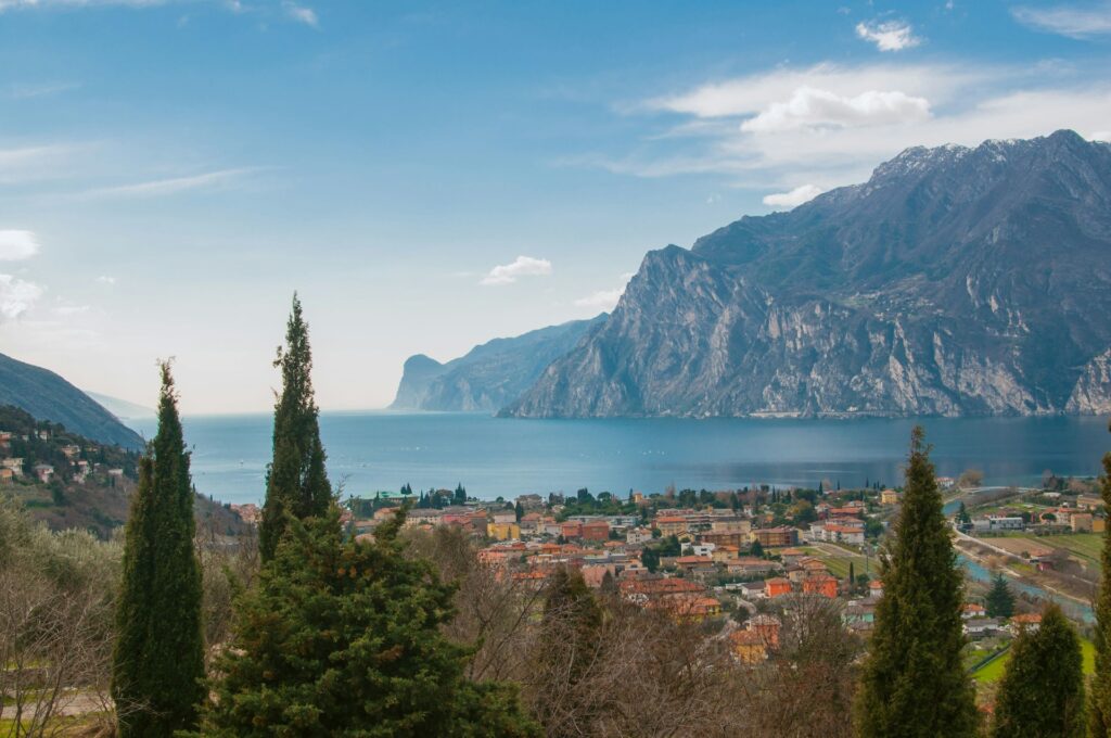 Alberi verdi vicino a uno specchio d'acqua durante il giorno, vista dall'alto sul Lago di Garda.